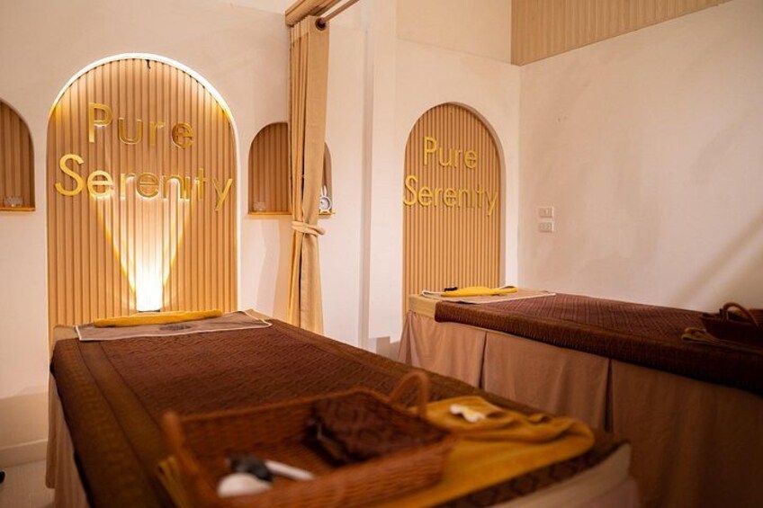 A spa room with two beds, wooden walls, and the words 'Pure Serenity' on the walls. 5