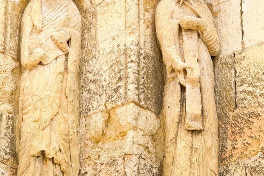 A carved stone relief of two figures in traditional attire, possibly from an ancient monument. 4