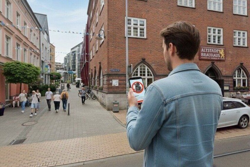 A person taking a photo of a street with pedestrians and a building labeled 'Altstadt Brauhaus.' 5
