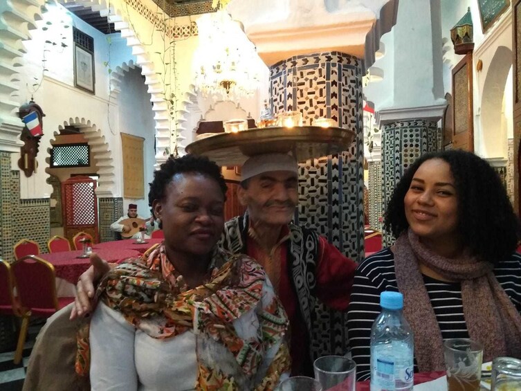 Two women pose with waiter at Tangier restaurant