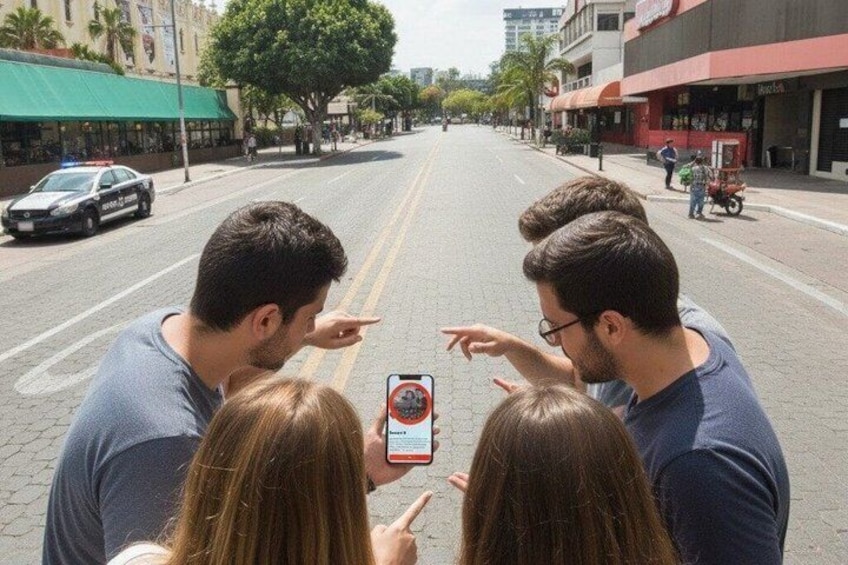 A street with a police car, a red vehicle, and people taking a photo. 2