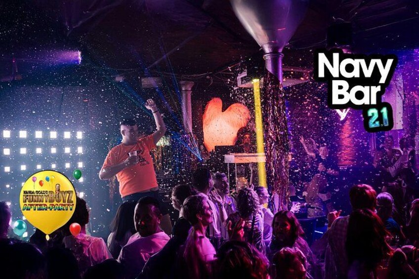 Eine lebhafte Indoor-Veranstaltung mit Bühne, Konfetti und einem DJ-Pult. 4