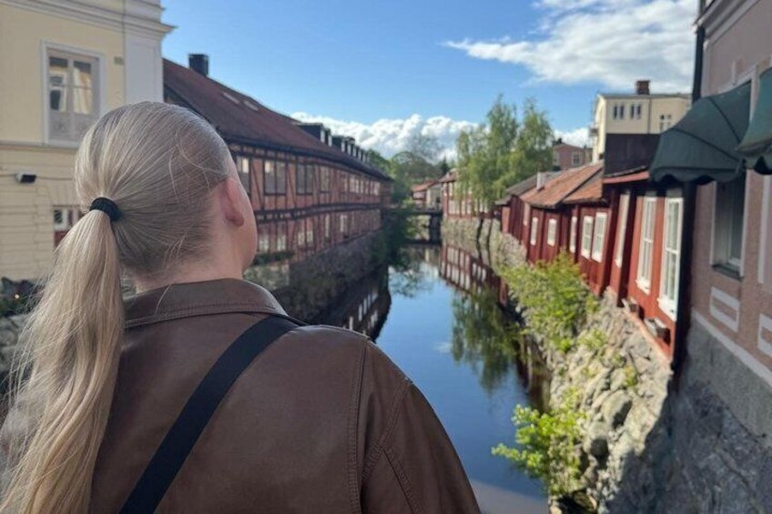 A canal with buildings on either side, a clear sky, and a person in the foreground. 1
