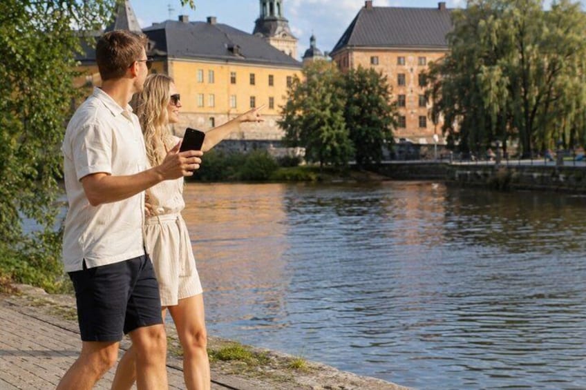 Two people standing by a river, one pointing at something in the distance. 4