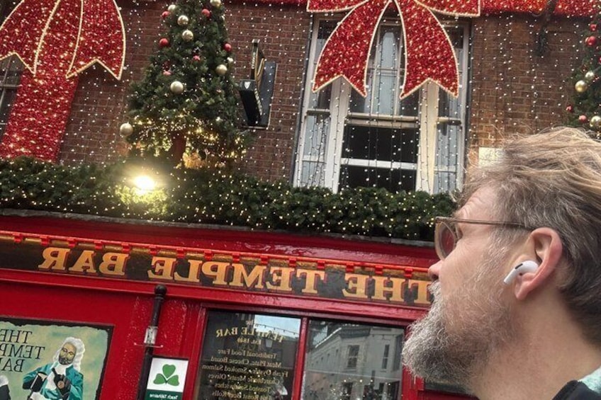 A Christmas tree and decorations on a building with a sign reading 'THE TEMPER BAR.' 3