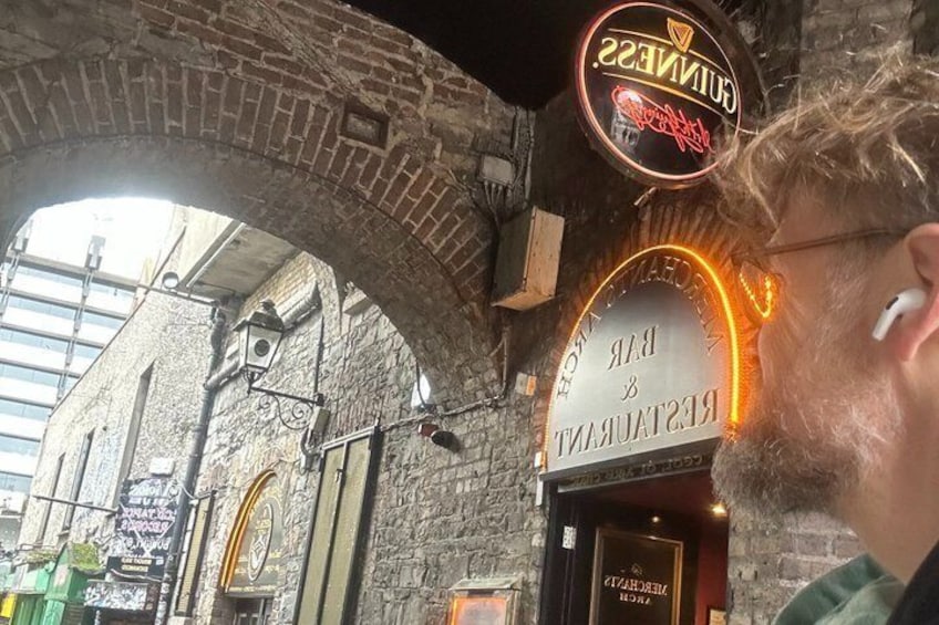 An old brick building with a neon sign for a bar and restaurant. 1