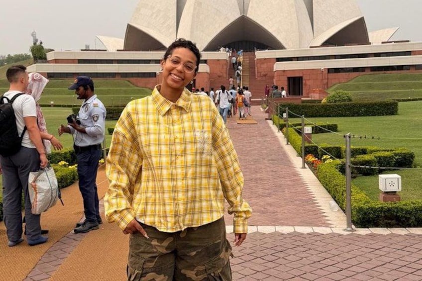 A person standing in front of a large, modern building with a unique architectural design. 3