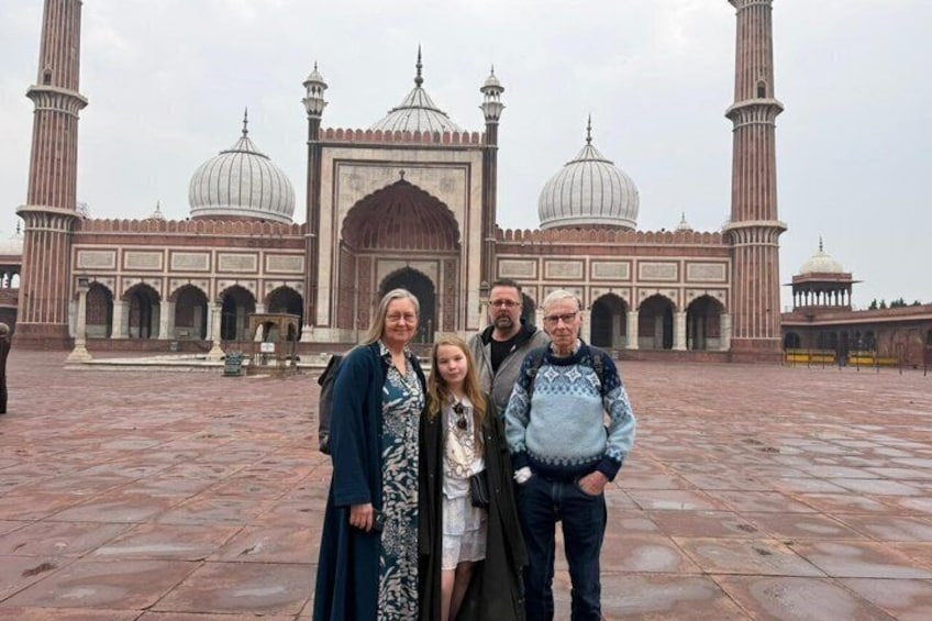 Eine Gruppe von Personen steht vor einem großen, historischen Gebäude mit Kuppeln und Minaretten. 2