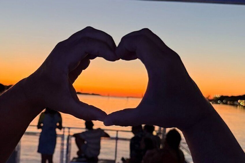 Des mains formant un cœur sur fond de coucher de soleil. 2