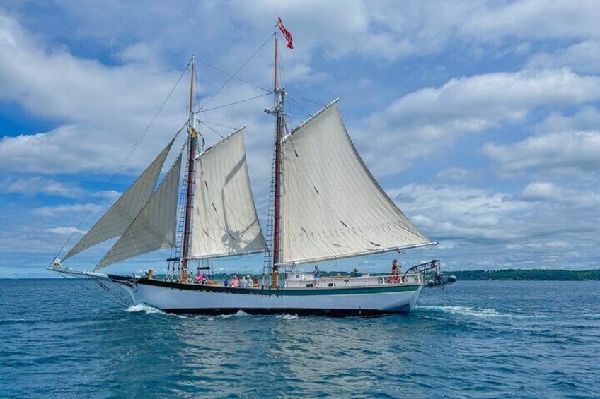A sailing boat with two masts and white sails on the water. 3
