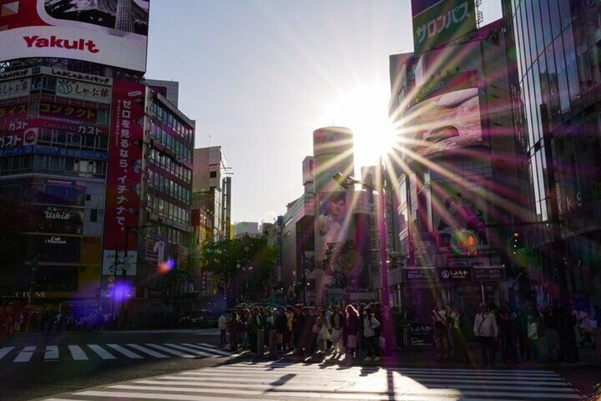 A busy urban street with a crosswalk and people crossing. 5