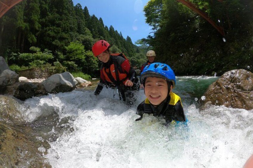 People kayaking on a river surrounded by rocks and trees. 1