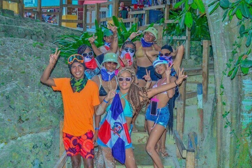 A group of people posing on a staircase with tropical plants in the background. 5