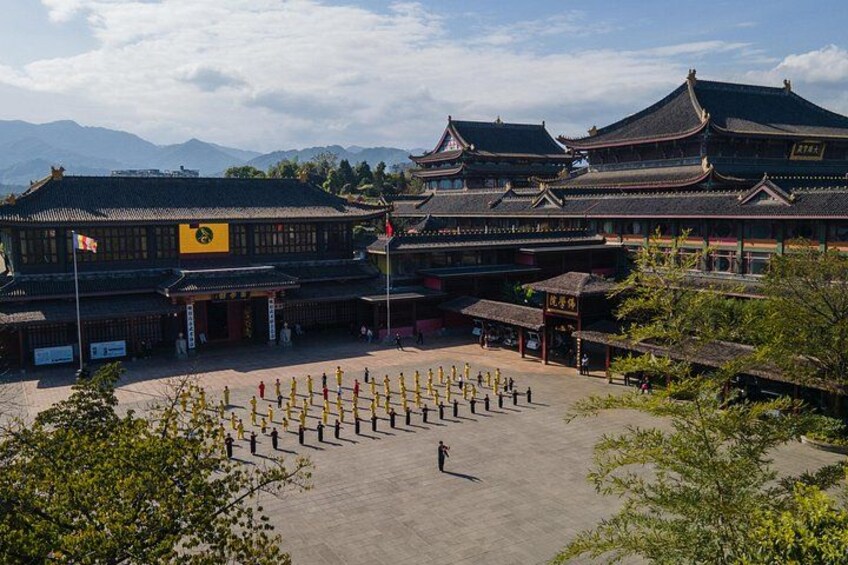 A traditional Chinese building with a courtyard, surrounded by trees and mountains in the background. 3