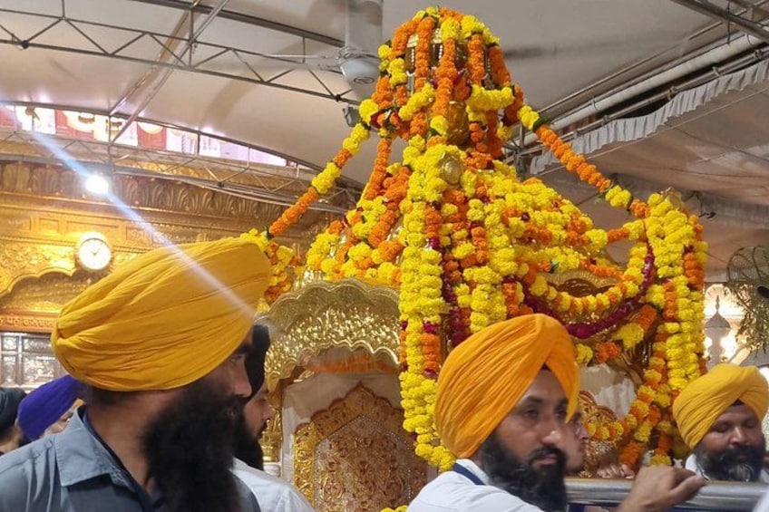 A person in a yellow turban, a decorated structure, and a clock. 5