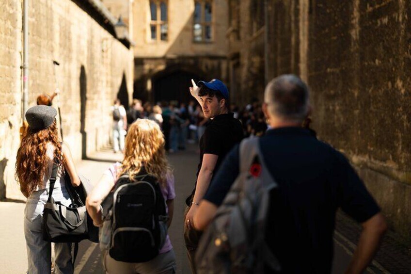 A group of people walking on a street with stone buildings. 1