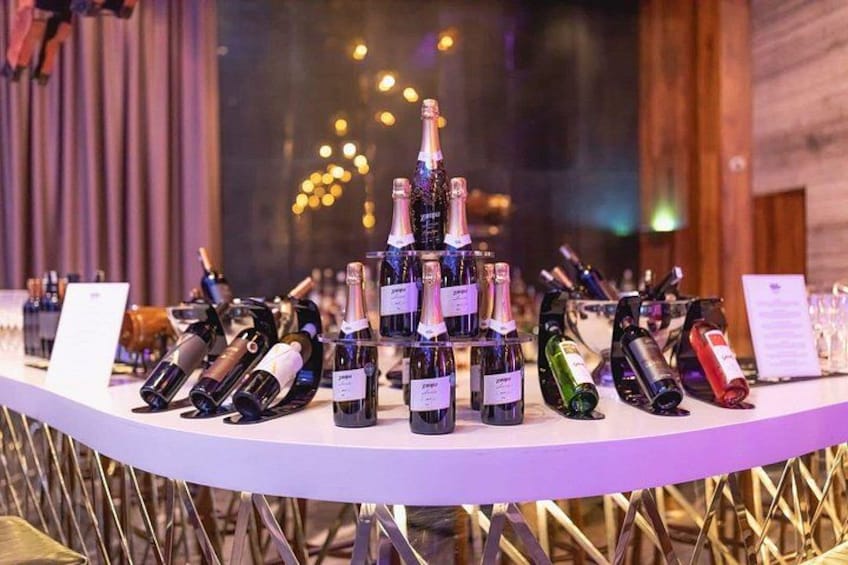 A bar with a variety of wine bottles arranged on shelves. 4
