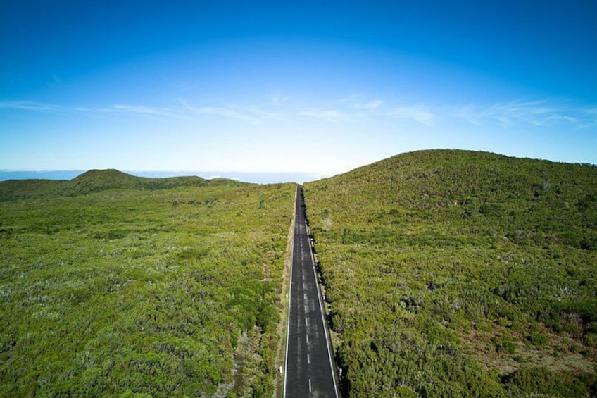 Eine lange, gerade Straße durch eine hügelige Landschaft. 2