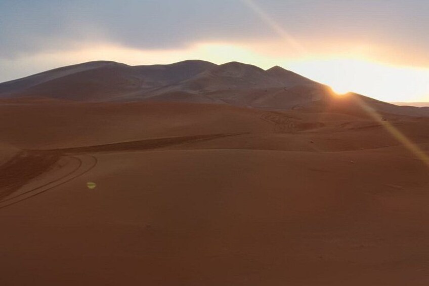 A desert landscape with sand dunes and mountains in the background. 4
