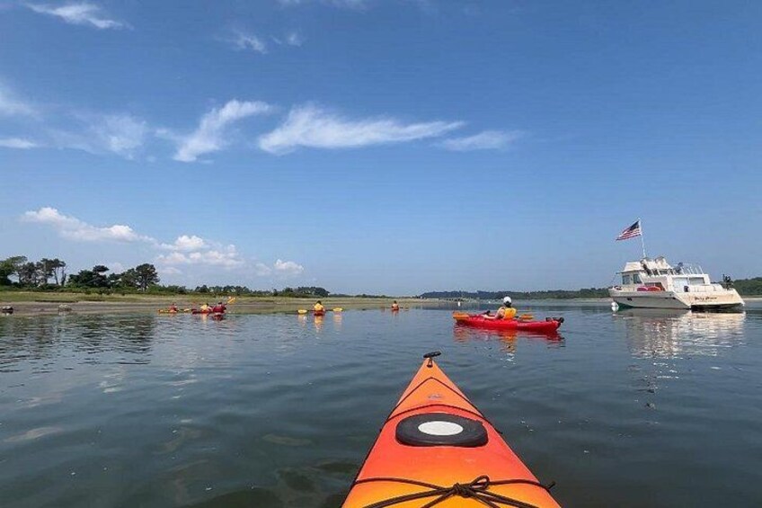 A calm river with kayaks and a boat. 3