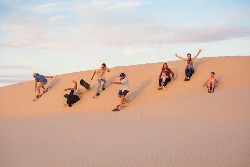 People sliding down a sand dune. 3