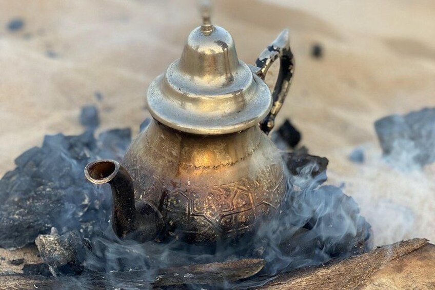 A metal container with a lid, emitting smoke, placed on a rock. 2