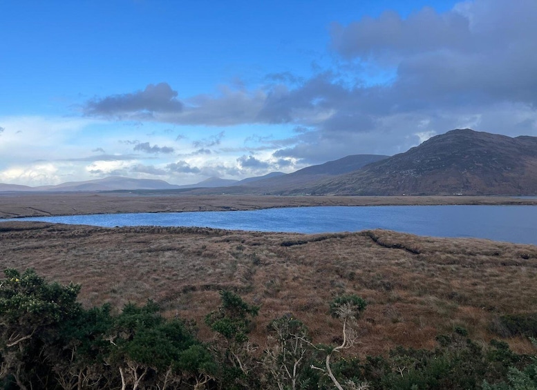 A lake surrounded by hills and sparse vegetation. 4