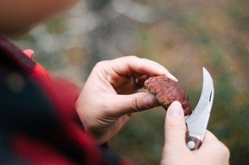 A person holding a nut with a knife. 2