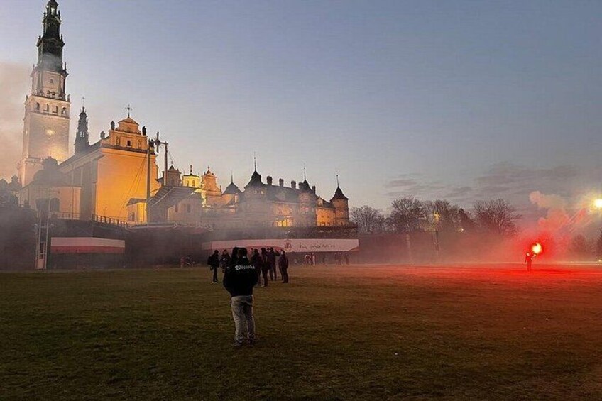 A castle with towers, a field, and a person holding a torch. 2