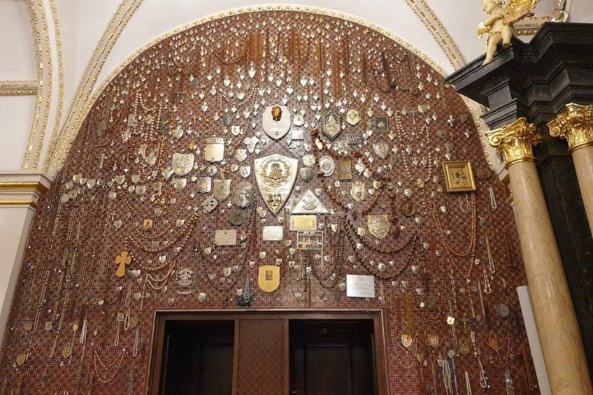 A richly decorated wall with intricate patterns and symbols, a large arched doorway, and golden columns. 4