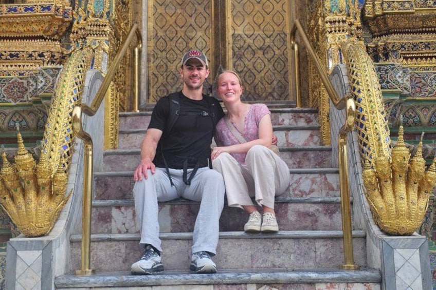 A man and a woman sitting on ornate stairs with golden decorations and intricate designs. 5
