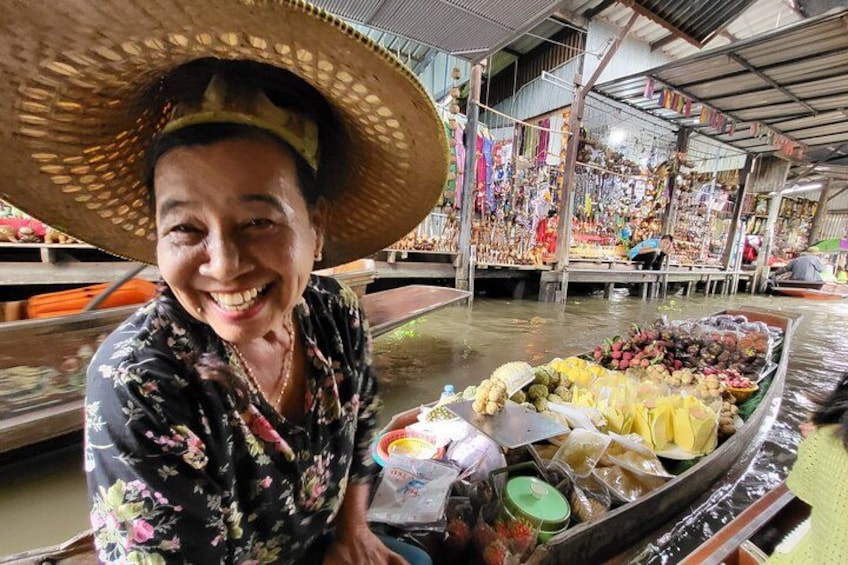 A person in a boat with a large hat, surrounded by various fruits and vegetables. 2
