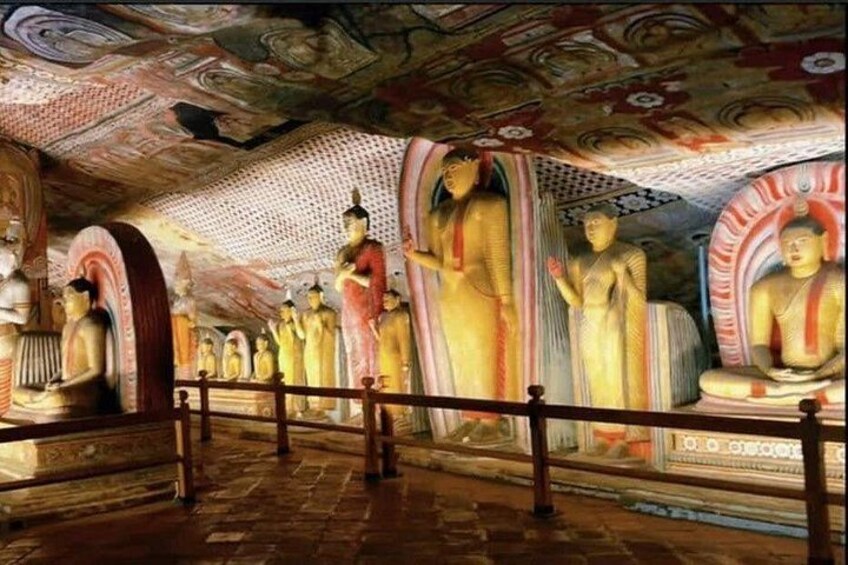 A temple with large Buddha statues and intricate ceiling artwork. 2