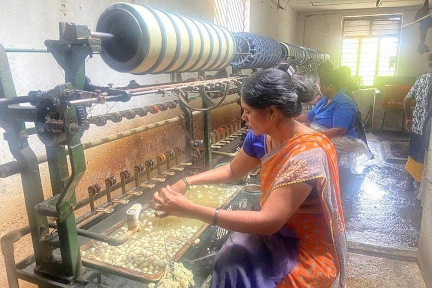 A woman operating a textile machine in a factory setting. 1