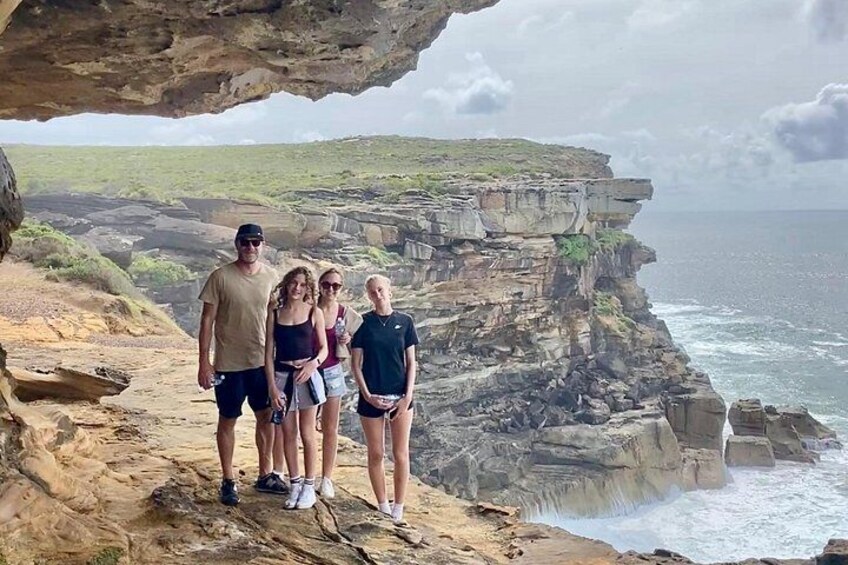A family standing on a rocky cliff overlooking the ocean. 1