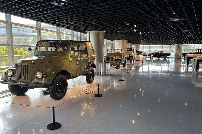 A museum interior with a vintage military jeep on display. 4