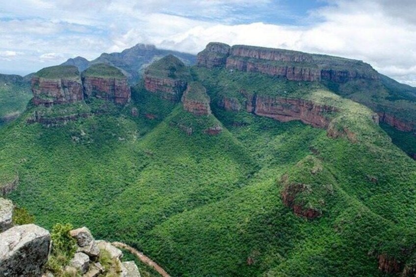 A mountainous landscape with green vegetation and rocky cliffs. 2