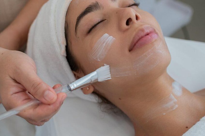 A person receiving a facial treatment with a brush. 3