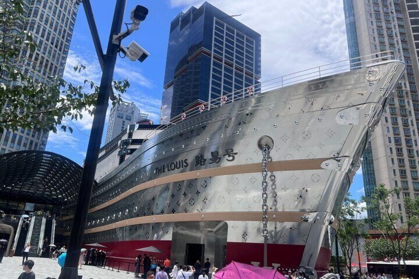 Una réplica grande y moderna del barco Titanic, The Louis, atracada en una ciudad con edificios altos al fondo. 5