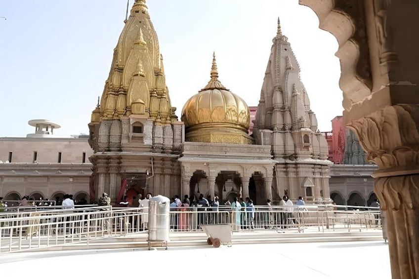 A temple with golden domes and spires, surrounded by a crowd of people. 3
