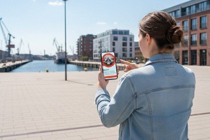 A person taking a photo with a smartphone in an urban waterfront setting. 5