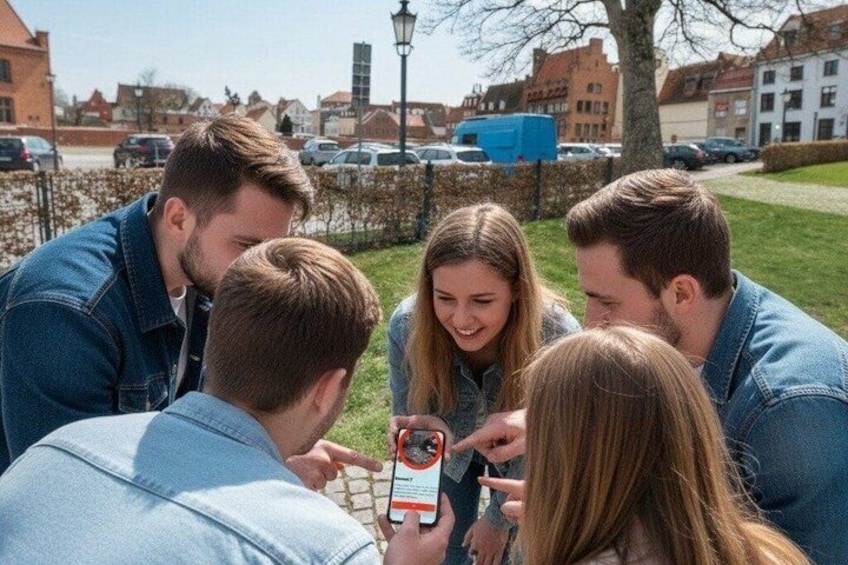 A group of people gathered outdoors, looking at a smartphone. 1