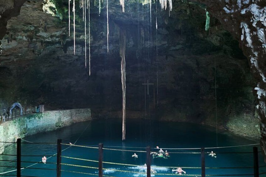 Una cueva con una escalera de cuerda, una piscina y estalactitas colgando del techo. 3