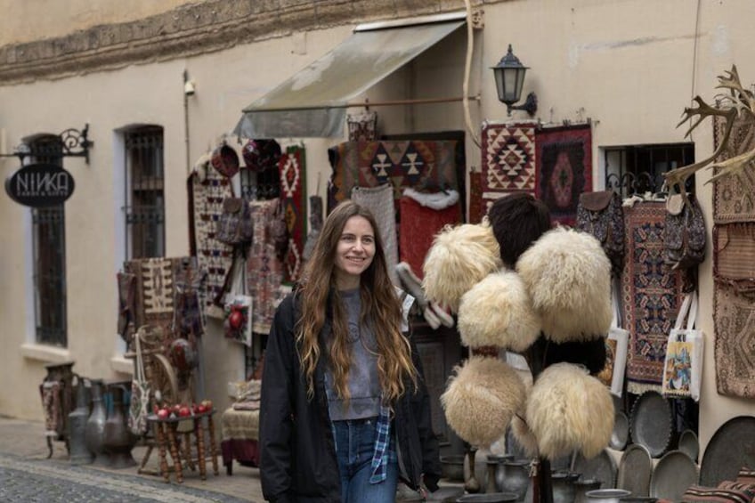 Een straat met een winkel die tapijten en textiel toont. 3