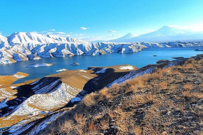 A mountainous landscape with a lake and snow-covered peaks. 3
