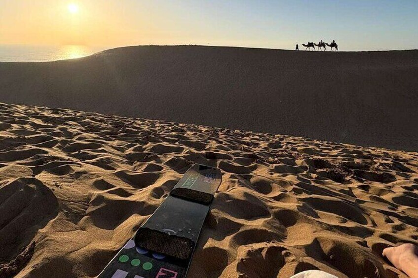 A desert landscape with sand dunes and a sunset in the background. 3