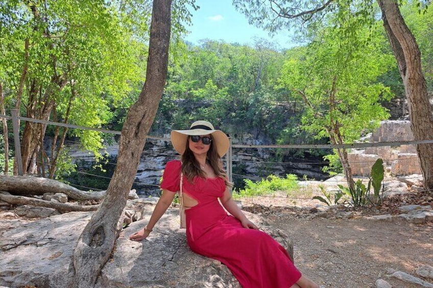 A person sitting on a rock in a natural setting with trees and a rocky landscape. 3
