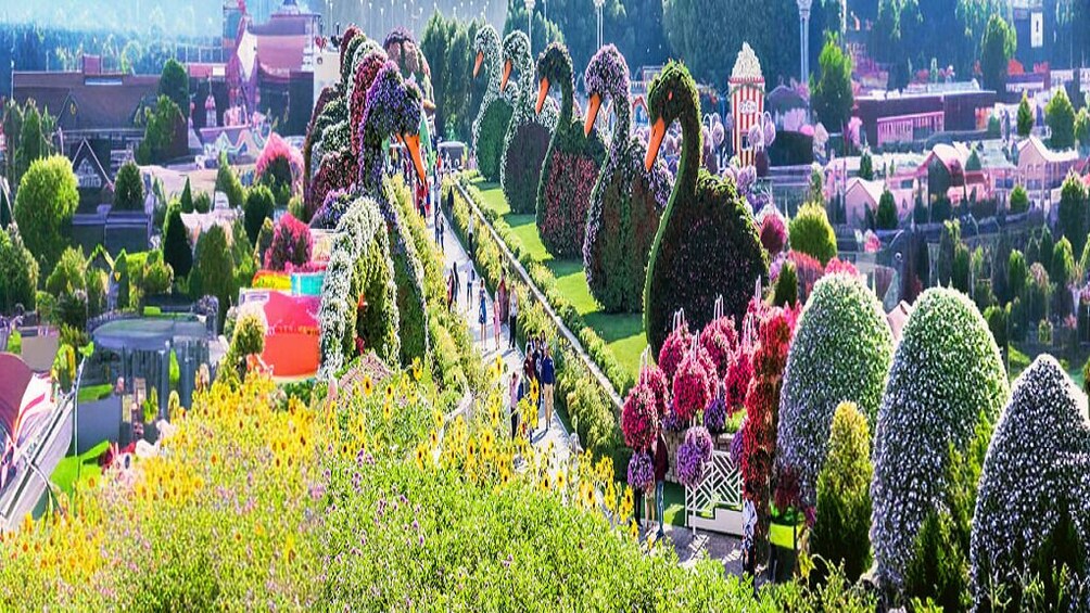 A garden with topiary sculptures, a pathway, and a variety of colorful flowers. 4