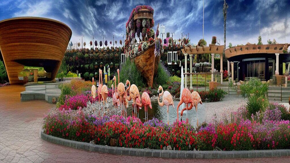 A large wooden structure, a boat-shaped building with flowers, flamingos, and a garden with colorful flowers. 3