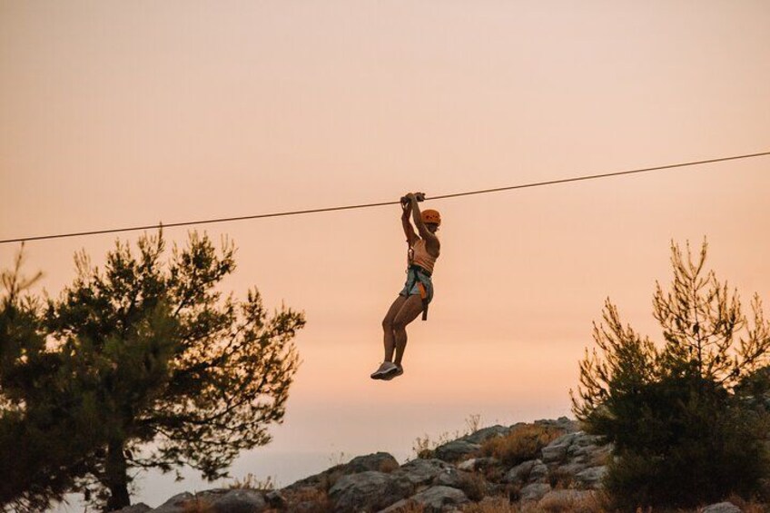 En person svæver i en zipline mellem træerne. 3